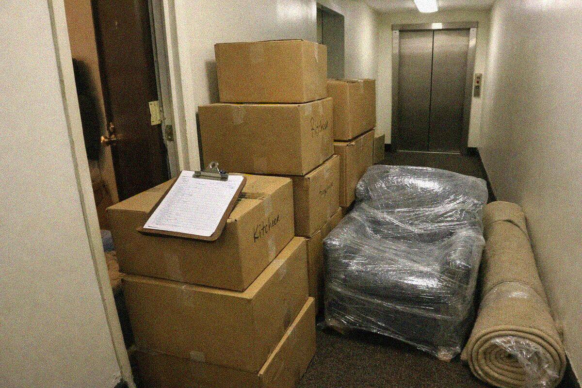 Labeled moving boxes stacked in the hallway of a New York apartment during a contents pack-out